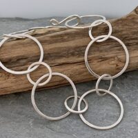 Image of a sterling silver chain bracelet made from large round, links that have a flat satin finish