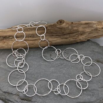 Image of a handmade silver chain necklace with round links that have a hammered finish