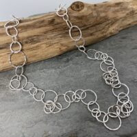 Image of a handmade sterling silver chain necklace made from delicate round links that have a sparkly hammered texture.