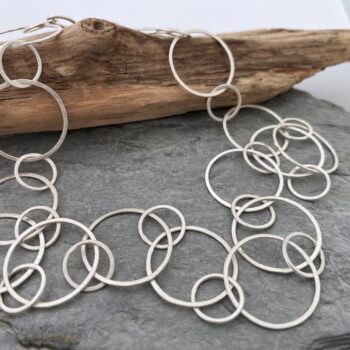 Image of a handmade sterling silver chain necklace with large round links that have a flat matte brushed finish
