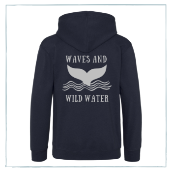 A navy blue hoodie with a metallic silver Waves & Wild Water logo, depicting a whale tail coming out of the water.