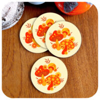 Set of four round 70s style coasters featuring cute mushrooms in orange and yellow.