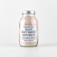 Pink bath salts in a clear glass jar.